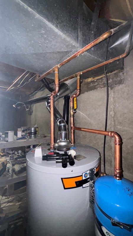 Completed installation of a 50-gallon gas-fired water heater in residential utility room. Unit was properly positioned and secured against concrete block wall with all necessary plumbing connections made using copper piping. Installed thermal expansion tank on the water supply line to protect against pressure buildup from thermal expansion. All gas connections, water supply lines, and temperature-pressure relief valve discharge piping were installed per manufacturer specifications and local code requirements. System was tested for proper operation and verified for no leaks. HVAC contractor to handle final collection of old equipment.