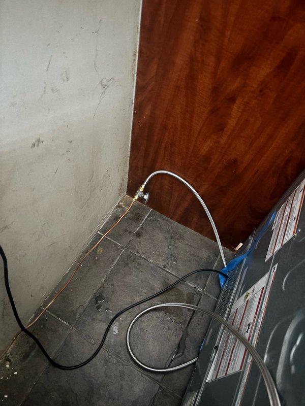Responded to low water pressure issue at refrigerator caused by incorrect water supply line installation. Removed improperly sized hose from water line connection and installed correct fitting and supply line to refrigerator. Verified proper water flow and confirmed operational status of both water dispenser and ice maker functions.