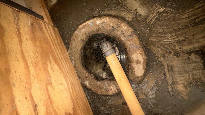 Responded to basement drain backup complaint and performed main drain cleanout service. Upon arrival, observed floor drain with visible water staining and mineral deposits on surrounding concrete, indicating chronic drainage issues. Successfully cleared main drain line using appropriate drain cleaning equipment, restoring proper flow and eliminating backup condition. Discussed preventive maintenance agreement upgrade options with customer for future consideration.