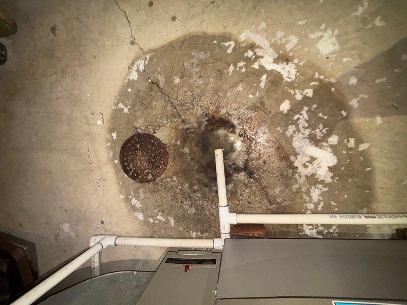 Responded to basement drain backup complaint and performed main drain cleanout service. Upon arrival, observed floor drain with visible water staining and mineral deposits on surrounding concrete, indicating chronic drainage issues. Successfully cleared main drain line using appropriate drain cleaning equipment, restoring proper flow and eliminating backup condition. Discussed preventive maintenance agreement upgrade options with customer for future consideration.