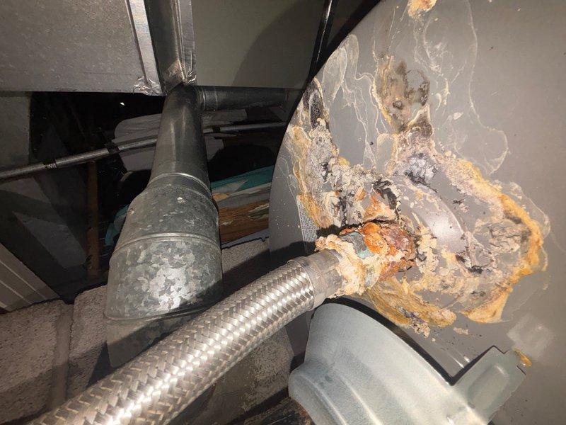 Responded to service call for tanked water heater not heating or turning on. Upon inspection, discovered significant water damage on utility room wall indicating previous or ongoing leak from water heater system. Examined water heater connections, copper supply lines, brass fittings, and associated plumbing components including whole-house water filtration system mounted in crawlspace area. Documented existing conditions with photographs showing extent of moisture damage, discoloration, and deterioration of wall surfaces near mechanical equipment. Assessed water heater functionality and related piping infrastructure to determine source of heating failure and water intrusion.