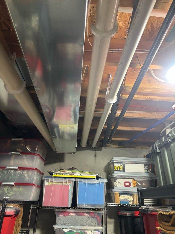 Responded to service call for tankless water heater replacement evaluation in basement location. Upon arrival, inspected existing wall-mounted tankless unit with front access panel removed to assess internal components including copper heating elements, control board, electrical connections, and brass fittings. Documented installation configuration including white PVC venting system, yellow corrugated gas line, and copper water supply connections mounted on concrete wall with wooden support beam. Evaluated unit condition and provided estimate for tankless water heater replacement based on customer requirements and existing gas utility infrastructure.
