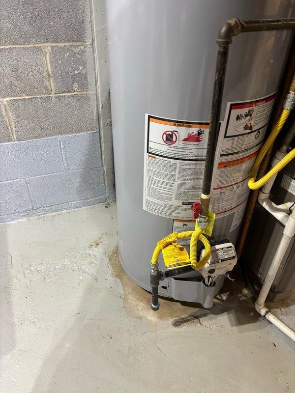 Completed installation of a 50-gallon residential gas water heater in basement utility room. Installed thermal expansion tank to protect against pressure buildup in the closed plumbing system. Installed 3/4-inch pressure reducing valve (PRV) to regulate incoming water pressure and protect plumbing fixtures. Connected gas supply using flexible yellow CSST gas line to water heater control valve. Verified all plumbing connections including copper supply lines and ensured proper venting. System tested and confirmed operational with all safety controls functioning correctly.