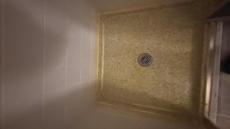 Responded to service call for main floor 32-inch walk-in shower experiencing water infiltration into basement below. Conducted thorough inspection of shower base, drain assembly, and surrounding tile work. Examined fiberglass shower pan with textured slip-resistant surface and center-mounted circular drain cover. Assessed condition of tile walls, grout lines, and floor-to-wall transitions for potential water penetration points. Documented shower enclosure configuration including threshold, drain grates, and wall tile installation. Photographed existing conditions showing shower base material, drain assembly, and overall enclosure layout to identify source of leak. Provided detailed estimate for fixture repairs needed to resolve water intrusion issue.