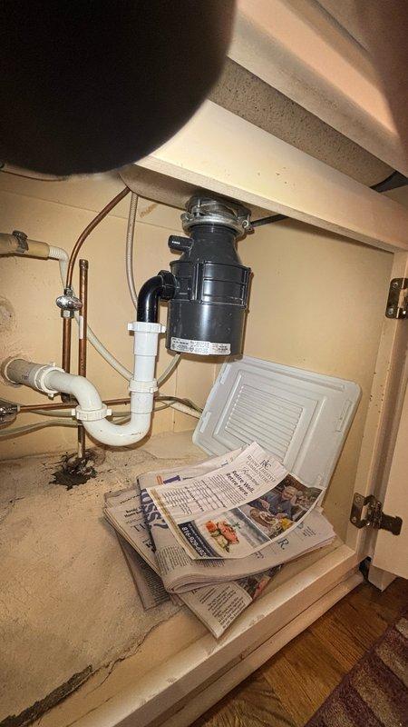 Responded to kitchen water leak complaint and performed thorough inspection of under-sink plumbing system. Identified leak source at water supply connection point where copper supply line meets shut-off valve assembly. Inspected garbage disposal unit, P-trap configuration, and all PVC drain connections for additional leak points. Tightened valve connections and assessed condition of supply line coupling showing visible wear and discoloration. Verified all drain connections were secure and properly sealed to prevent future leakage issues.