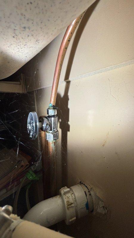 Responded to kitchen water leak complaint and performed thorough inspection of under-sink plumbing system. Identified leak source at water supply connection point where copper supply line meets shut-off valve assembly. Inspected garbage disposal unit, P-trap configuration, and all PVC drain connections for additional leak points. Tightened valve connections and assessed condition of supply line coupling showing visible wear and discoloration. Verified all drain connections were secure and properly sealed to prevent future leakage issues.