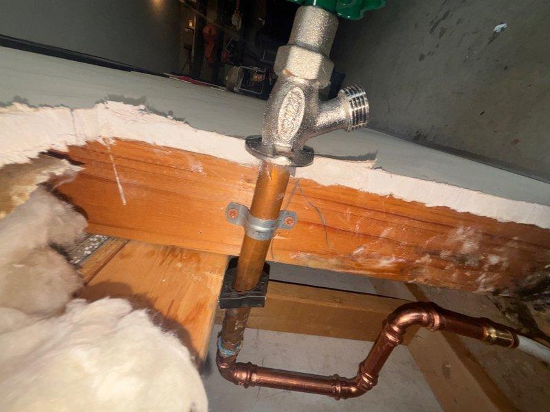 Installed a 3/4" brass pressure reducing valve (PRV) on the main water line in the attic space, connecting it between existing copper piping using compression fittings to regulate incoming water pressure. Repaired a woodford-style frost-proof hose bib by installing new copper piping with proper expansion loop configuration and securing all connections with soldered joints and appropriate mounting hardware to wooden framing members.