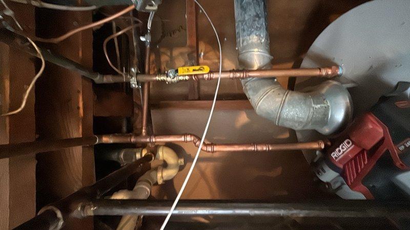 Installed water shut-off valve on copper supply line to accommodate new dishwasher installation. Accessed plumbing beneath floor joists, cut into existing copper water line, and installed brass quarter-turn shut-off valve with compression fittings to provide dedicated water supply control for appliance connection.