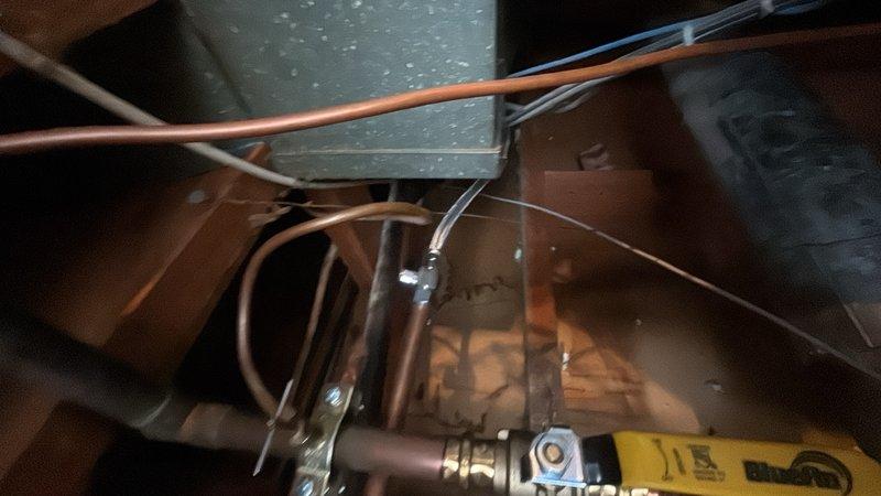 Installed water shut-off valve on copper supply line to accommodate new dishwasher installation. Accessed plumbing beneath floor joists, cut into existing copper water line, and installed brass quarter-turn shut-off valve with compression fittings to provide dedicated water supply control for appliance connection.