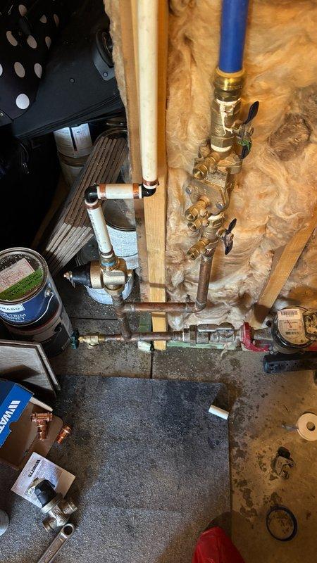 Responded to service call for low water pressure affecting bathroom sink, shower, and toilet. Diagnosed air in water lines indicated by gurgling sounds reported during toilet flushing. Inspected tankless water heater installation, plumbing connections, and supply lines in utility area. Verified proper operation of shut-off valves, checked copper and PEX pipe connections for restrictions or blockages, and assessed system for potential air infiltration points that could cause intermittent pressure loss throughout bathroom fixtures.
