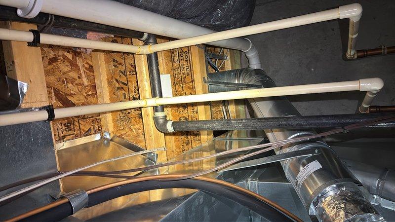 Conducted site assessment for gas line installation to accommodate conversion from electric to gas range in kitchen. Evaluated existing utility infrastructure including access points through ceiling cavity and mechanical spaces to determine optimal routing for new gas supply line. Documented current plumbing configuration, PVC drainage systems, HVAC ductwork placement, and structural framing to plan gas line path from main supply to kitchen appliance location. Assessed potential water line installation requirements for refrigerator ice maker connection and identified access points at wall-ceiling junction for future installation.