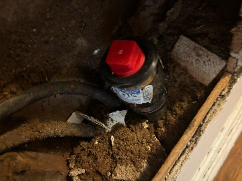 Responded to report of water leak from bathroom ceiling. Accessed crawlspace beneath bathroom to identify source of leak. Inspected plumbing infrastructure including drain lines and supply pipes in affected area. Located compromised plumbing component with red valve assembly in crawlspace showing signs of moisture intrusion. Examined vertical drain stack and associated piping where rust staining and discoloration were visible on painted metal pipe surfaces. Documented conditions with photographic evidence for service records. Advised on necessary repairs to resolve leak and prevent further water damage to ceiling below.