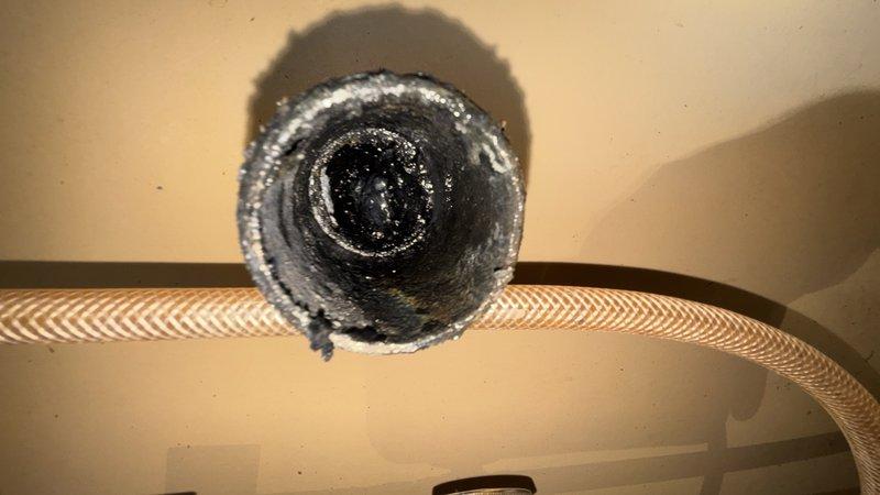Responded to a recurring main drain backup in the basement, previously serviced two months prior. Performed cleanout of the main drain line to restore proper drainage and flow. Documented existing conditions including under-sink plumbing connections and HVAC ductwork in the service area for reference.
