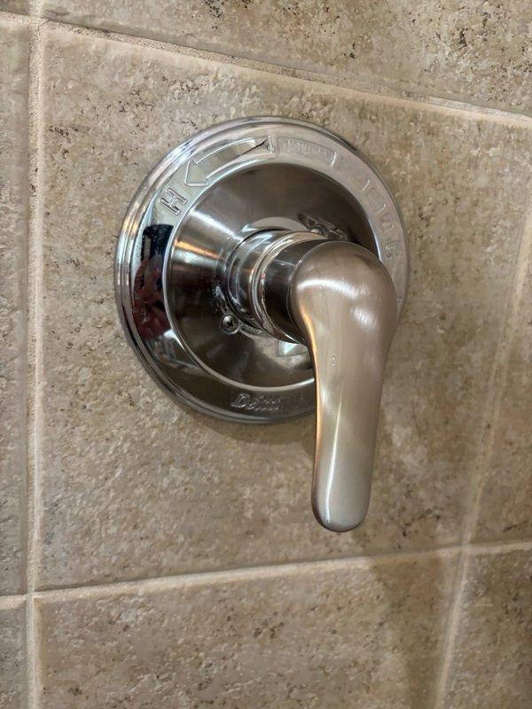 Serviced shower faucet control valve in master bathroom, inspecting the Delta chrome fixture mounted on tiled wall and ensuring proper operation. Installed new freeze-proof outdoor faucet on exterior wall to replace aging brass fixtures showing significant corrosion and mineral deposits, providing enhanced freeze protection for the 26-year-old home.
