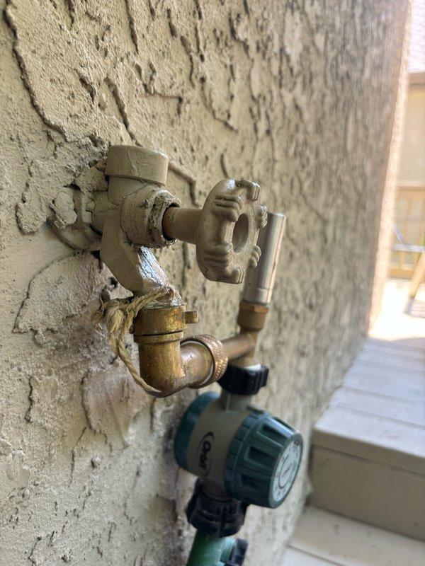 Serviced shower faucet control valve in master bathroom, inspecting the Delta chrome fixture mounted on tiled wall and ensuring proper operation. Installed new freeze-proof outdoor faucet on exterior wall to replace aging brass fixtures showing significant corrosion and mineral deposits, providing enhanced freeze protection for the 26-year-old home.