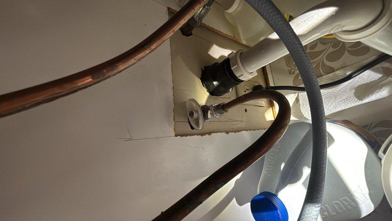 Completed comprehensive whole home plumbing inspection, examining all accessible water supply lines, drain systems, and fixtures throughout the property. Inspected under-sink plumbing connections, identifying aging copper supply lines with visible patina and corrosion, white PVC drain assemblies, and black trap mechanisms through ceiling access point. Evaluated bathroom plumbing system, including chrome handheld showerhead assembly mounted on flexible hose, tub spout, and associated fixtures. Provided estimate for tub faucet repair to address operational concerns.