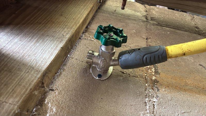 Replaced failed frost-free outside hose bib by accessing crawl space and cutting the existing water line. Enlarged the exterior wall penetration to accommodate the new frost-free hose bib installation. Installed a new brass shut-off valve with green handle upstream of the hose bib to provide isolation capability for future maintenance or emergency situations. All connections were secured and tested for proper operation and leak-free performance.