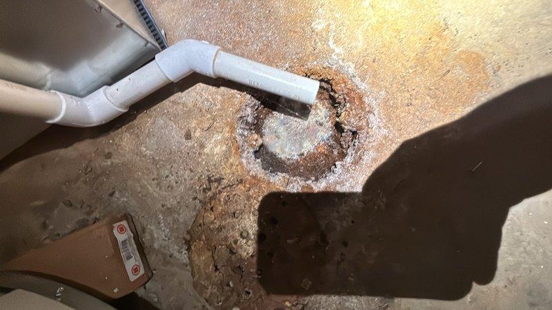 Completed comprehensive inspection of two floor drains exhibiting heavy rust and mineral buildup. Assessed drain functionality, structural integrity, and drainage capacity to determine whether repairs or replacement would be necessary. Documented conditions with photographs showing significant efflorescence, corrosion patterns, and sediment accumulation around drain components and PVC piping connections.
