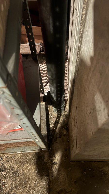 Performed camera inspection of plumbing system in basement utility area. Visual documentation captured condition of vertical drain pipe, surrounding concrete block walls showing moisture damage and deterioration, and floor conditions with visible rust and water exposure indicators.