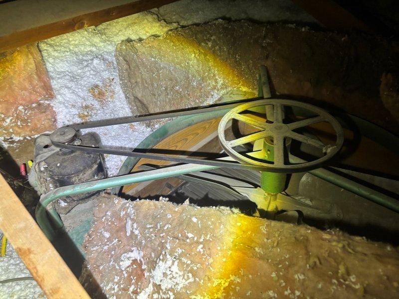 Responded to emergency water leak originating from attic space affecting multiple interior walls on split-level residence. Upon inspection, identified water heater as source of leak with water infiltrating through ceiling at four separate wall locations. Accessed attic crawl space to assess damage and locate primary leak point. Found water saturation in fiberglass insulation surrounding water heater area with evidence of mineral deposits on reflective insulation surfaces. Isolated water supply to water heater and addressed active leak. Documented extent of water damage to insulation materials and mechanical systems in attic space for insurance and repair purposes.