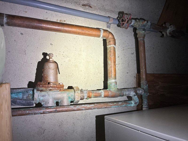 Completed estimate for replacement of 20+ year old 40-gallon gas water heater located in basement. Existing unit is currently operational but showing signs of age with visible corrosion on associated copper piping, oxidation on plumbing assembly components, and mineral deposit buildup around pipe joints and fittings. Provided pricing and recommendations for new 40-gallon gas water heater installation.