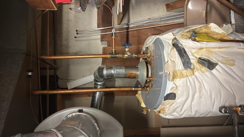 Completed estimate for replacement of 20+ year old 40-gallon gas water heater located in basement. Existing unit is currently operational but showing signs of age with visible corrosion on associated copper piping, oxidation on plumbing assembly components, and mineral deposit buildup around pipe joints and fittings. Provided pricing and recommendations for new 40-gallon gas water heater installation.
