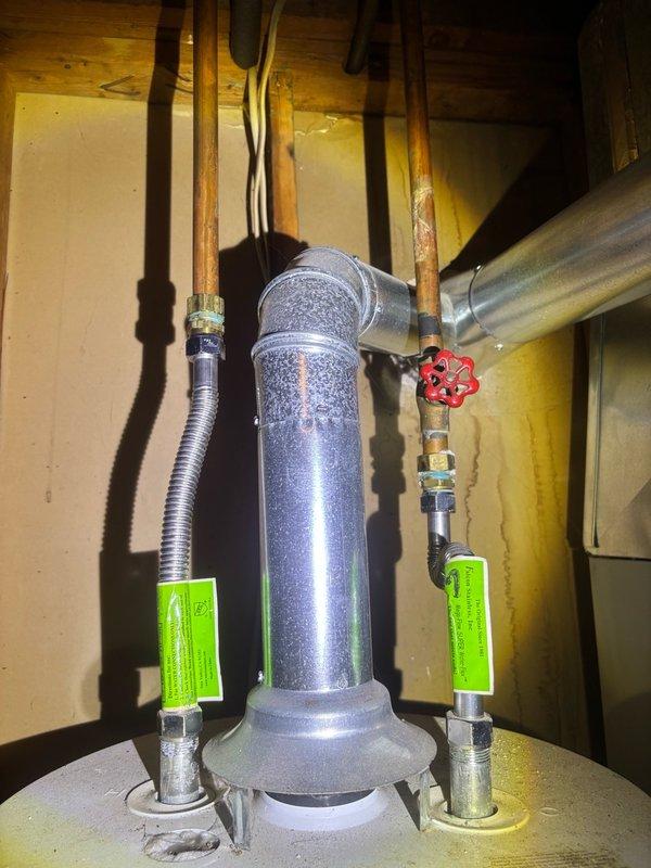 Completed plumbing maintenance visit including inspection of water heater and plumbing fixtures. Performed visual assessment of water heater in mechanical space, noting proper condensation patterns and verifying all safety tags and valve operations were intact. Tested bathroom sink faucet for proper water flow and drainage, confirming three-handle fixture was operating correctly with adequate water pressure and no leaks detected.