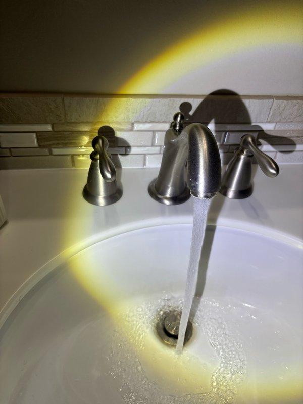 Completed plumbing maintenance visit including inspection of water heater and plumbing fixtures. Performed visual assessment of water heater in mechanical space, noting proper condensation patterns and verifying all safety tags and valve operations were intact. Tested bathroom sink faucet for proper water flow and drainage, confirming three-handle fixture was operating correctly with adequate water pressure and no leaks detected.