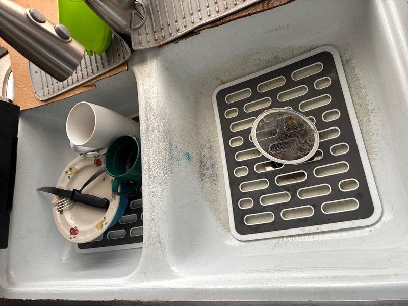 Performed comprehensive whole home plumbing inspection at customer's request with no reported issues. Conducted thorough visual assessment of accessible plumbing fixtures, supply lines, drain systems, and water heating equipment throughout the residence. 

Inspected kitchen sink assembly, confirming proper drainage function and evaluating condition of double-basin fixture with center divider configuration. Observed minor mineral deposits and water staining on basin surfaces, consistent with normal use and hard water conditions. Verified drain covers and strainers were properly seated and functional.

Examined water heater installation and associated plumbing connections in utility area. Inspected brass valve assemblies, shut-off valves, and supply line connections for proper installation and potential leaks. Evaluated condition of flexible supply hoses, confirming secure attachment points and absence of visible deterioration. Verified temperature and pressure relief valve accessibility