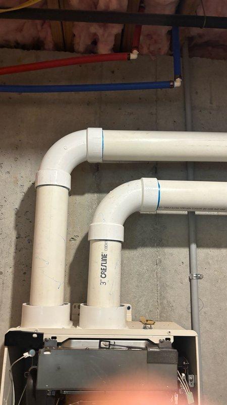 Responded to Error 29 code on tankless water heater system. Inspected unit and verified proper venting configuration with 3-inch PVC exhaust and intake pipes installed with appropriate 90-degree elbows extending through floor joists. Cleared error code by addressing combustion air flow issue and confirmed all venting connections were secure and properly sealed. System tested and returned to normal operation with no further error codes displayed.