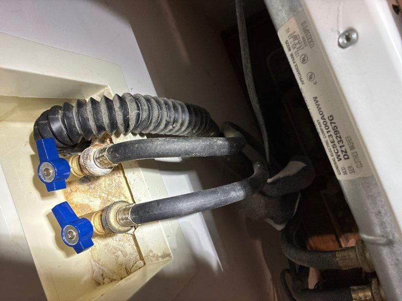 # Plumbing Inspection Report

Completed comprehensive whole home plumbing inspection including evaluation of water pressure, supply line connections, and shut-off valve functionality. Water pressure tested at 60-65 PSI using calibrated pressure gauge, confirming adequate system pressure within normal residential operating range. Inspected dual brass quarter-turn ball valves with blue handles serving appliance water supply lines, noting minor mineral deposits and tarnishing on valve bodies consistent with normal aging but no signs of active leaks or operational deficiencies. Verified proper installation of black corrugated flexible supply hoses with compression fittings and confirmed secure connections at all points. Examined copper pipe connections and mounting hardware, finding all components properly secured and functioning as intended with no immediate repair needs identified.