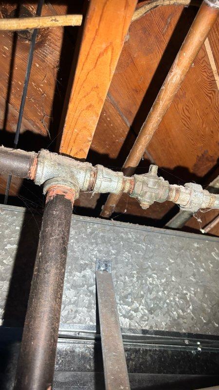 Responded to service call for gas line capping in chimney chase located in downstairs living area. Upon arrival, assessed the gas line configuration in deteriorated interior space showing significant moisture damage and staining. Successfully capped off the gas line per code requirements to ensure safe disconnection of gas supply. Inspected associated piping infrastructure in attic space above, confirming proper connection points and verifying no additional gas lines required attention in the vicinity of HVAC equipment and structural framing.