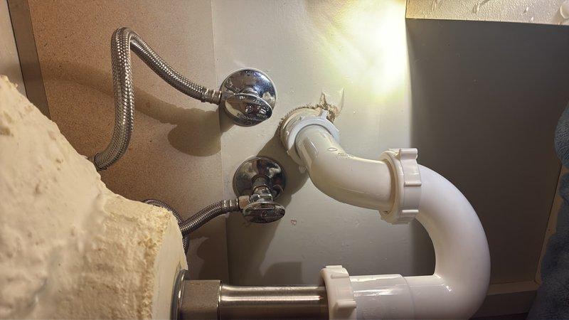 Completed faucet replacement and supply line installation at residential bathroom sink. Removed existing faucet assembly and installed customer-provided replacement fixture with new flexible braided stainless steel supply lines connected to existing shutoff valves. Verified proper water flow, tested for leaks at all connection points, and confirmed drain assembly functioning correctly with existing white PVC P-trap configuration intact.