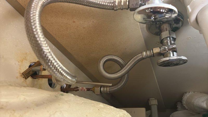 Completed faucet replacement and supply line installation at residential bathroom sink. Removed existing faucet assembly and installed customer-provided replacement fixture with new flexible braided stainless steel supply lines connected to existing shutoff valves. Verified proper water flow, tested for leaks at all connection points, and confirmed drain assembly functioning correctly with existing white PVC P-trap configuration intact.