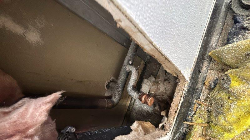 Responded to a leaking water line cap in the bathroom area. Upon inspection, located the compromised copper water line with a failing cap that was allowing water seepage. Removed the defective cap and properly capped off the water line using appropriate brass fittings to ensure a watertight seal. Verified the repair held pressure and confirmed no additional leaks were present in the immediate plumbing system. Work area was accessed through confined space requiring careful maneuvering around existing HVAC ductwork and framing.
