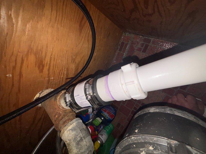 Responded to leak complaint under kitchen sink in drain system. Upon inspection, located leak at P-trap connection point beneath sink cabinet. Observed compromised seal at PVC P-trap fitting with visible moisture present. Inspected associated drain lines and supply connections in adjacent crawl space area to verify leak source and assess extent of water intrusion. Documented plumbing configuration including P-trap assembly, flexible supply lines, and connection points for service records.