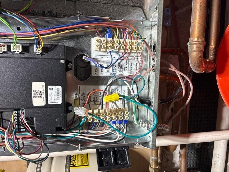 Conducted on-site evaluation for tankless water heater and boiler installation. Assessed existing plumbing infrastructure including PEX manifold distribution system with multiple zone lines, documented HVAC control panel wiring and terminal connections, and photographed current equipment configuration to develop comprehensive installation estimate for new heating system components.