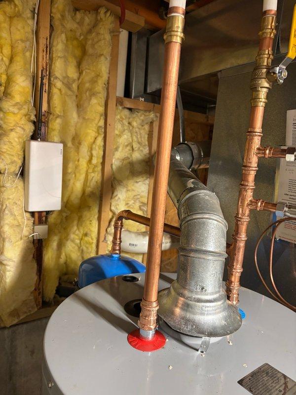 Completed installation of a 40-gallon gas-fired water heater in basement utility area. Installed thermal expansion tank to protect plumbing system from thermal expansion pressure, mounting it horizontally on the cold water supply line. Configured all copper piping connections to tank inlet and outlet with appropriate brass fittings, including temperature and pressure relief valve discharge piping per code requirements. Verified all gas connections, tested for leaks, and confirmed proper venting. System was filled, purged of air, and tested for proper operation with no leaks detected.