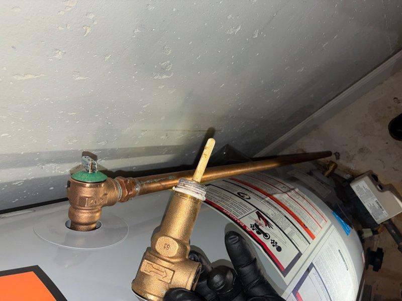 Responded to reported leak on 50-gallon gas water heater with power vent located in basement. Upon inspection, confirmed active water seepage from underneath tank assembly, indicating internal tank failure. Evaluated pressure relief valve, supply connections, and drain valve for potential leak sources; determined leak originated from compromised tank bottom rather than serviceable components. Documented condition of existing copper supply piping, mounting hardware, and venting system. Advised customer that tank replacement is necessary as internal tank corrosion and failure cannot be repaired.
