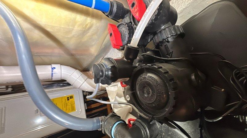 Replaced refill port assembly on Lindyspring water softener system. Installed part number CV3395, which includes integrated chlorine generator (black) and CV3395-G salt monitor (gray) as a single assembly unit. System tested and verified operational upon completion.