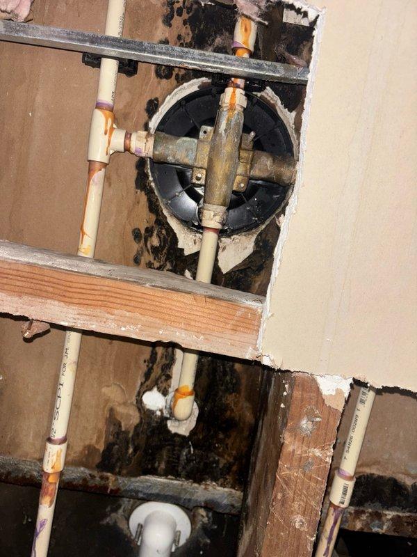 Responded to water leak in basement ceiling originating from main floor bathroom. Upon investigation, identified active leak occurring only during tub/shower operation. Accessed plumbing assembly through basement ceiling opening and inspected drain connections beneath bathtub fixture. Found deteriorated drain gasket and compromised seal at tub shoe connection, consistent with age of original plumbing installation in 80-year-old home. Removed existing drain assembly, cleaned mating surfaces, and installed new tub drain with fresh plumber's putty and rubber gasket. Tightened all connections to proper torque specifications. Conducted water flow test by running shower for extended period while monitoring drain assembly from below. Confirmed complete elimination of leak with no visible water penetration through ceiling. Documented existing condition of copper supply lines showing oxidation typical of aged plumbing systems for future reference.