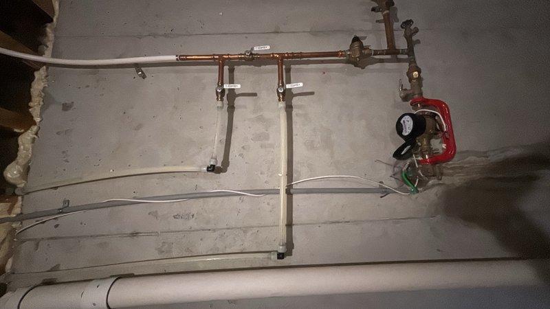 Responded to service call for malfunctioning bathroom faucet. Upon inspection, traced water supply lines from bathroom fixture to main plumbing infrastructure in basement utility area. Evaluated water pressure system including pressure gauge, valve assembly, and copper supply lines to identify root cause of faucet malfunction. Documented existing plumbing conditions including mounting hardware, pipe connections, and pressure regulation components for diagnostic purposes.