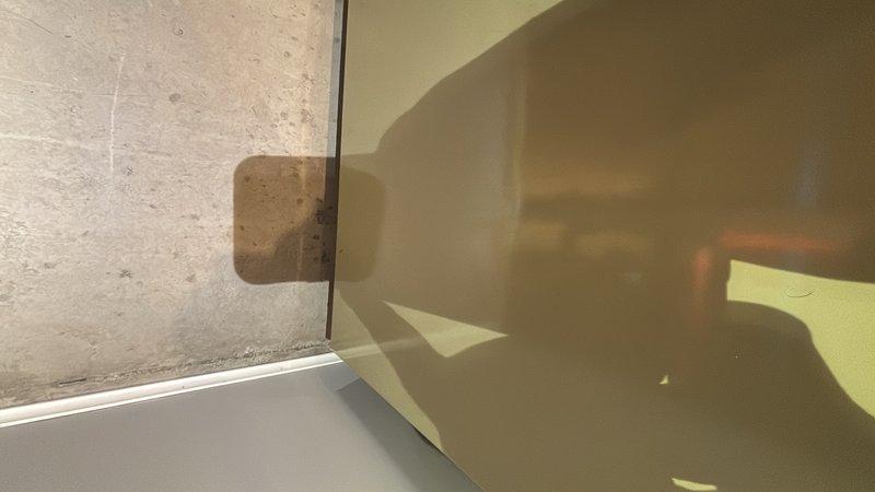 Responded to report of water leaking from under shower pan after use. Performed thorough inspection of shower enclosure, including examination of tile work, grout lines, and shower pan integrity. Inspected modern marble-pattern porcelain tile installation on walls and floor, checking for compromised grout joints and potential water intrusion points. Examined glass shower enclosure seals and mounting hardware for proper installation and waterproofing. Documented findings with photos showing tile condition and enclosure assembly. Identified potential leak source and provided recommendations for repair to prevent continued water migration beneath shower pan.