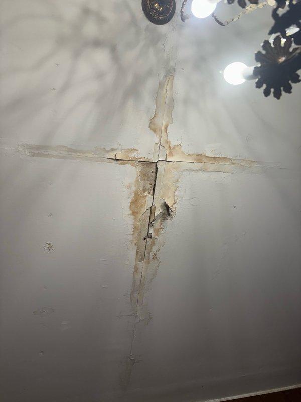 Responded to emergency call for ruptured toilet supply line on second floor. Upon arrival, found active water leak from failed supply line connection causing significant water damage to ceiling below. Immediately shut off water supply to affected fixture to prevent further damage. Assessed extent of damage, which included substantial water intrusion through floor penetration resulting in ceiling deterioration with visible cracking, staining, and material separation on lower level. 

Removed damaged supply line and inspected connection points for corrosion or deterioration. Installed new braided stainless steel supply line with proper torque specifications and verified all connections for leaks. Restored water supply and conducted pressure test to ensure system integrity. Documented water damage to ceiling and surrounding areas for insurance purposes. Advised property owner of need for professional water damage remediation and ceiling repair by qualified contractor.