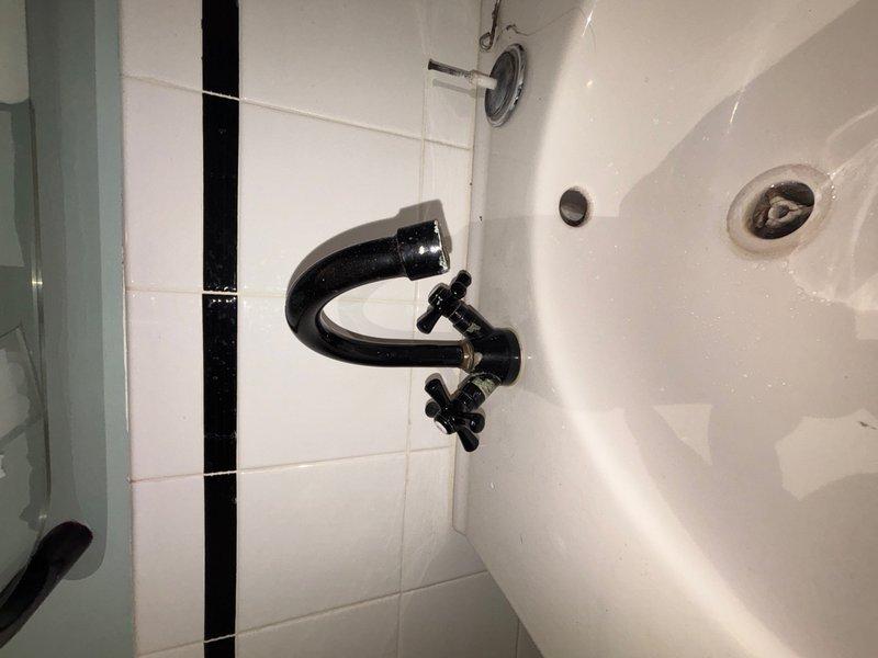 Responded to reported leak at exterior hose spigot at rear of property. Upon arrival, inspected outdoor faucet and confirmed active leak when valve was in open position. Located and identified main water shutoff valve for property and demonstrated operation to occupant. Additionally, inspected interior bathroom plumbing fixtures including wall-mounted faucet assembly with cross-handle controls and verified proper operation of sink drainage system. All accessible plumbing connections were checked for signs of moisture or deterioration.