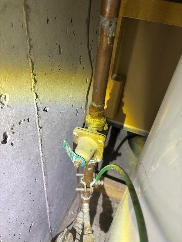 Completed comprehensive plumbing inspection of residential property. Documented exterior hose bib with active water leak requiring immediate attention, as well as interior gas shut-off valve and copper piping system showing age-related wear and wall damage in mechanical space.