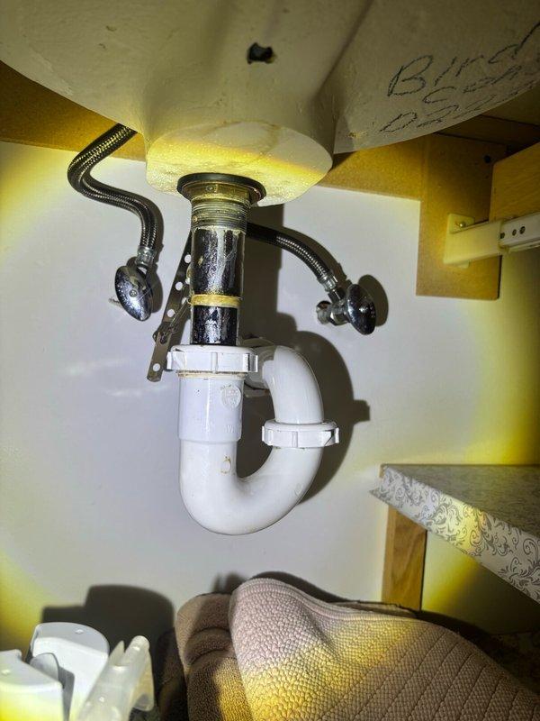 Completed comprehensive plumbing inspection of residential property. Inspected under-sink plumbing assembly including chrome drain with threaded connections, dual flexible supply lines with metal fittings, and white PVC P-trap configuration, confirming proper installation and functionality. Examined pressure gauge assembly with brass valve body, flexible metal braided hose, and circular dial gauge displaying appropriate pressure readings. All plumbing components, connections, and fixtures found to be in satisfactory working condition with no visible leaks or immediate concerns identified.