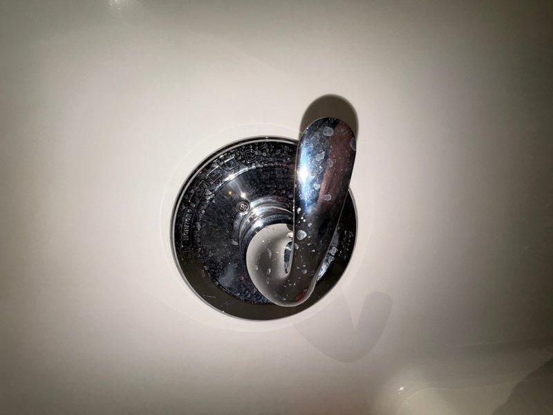 Completed comprehensive plumbing inspection as part of promotional service offering. Examined shower valve assemblies in two separate bathroom locations, documenting conditions through photographic evidence. First inspection area revealed oil-rubbed bronze shower valve and trim mounted on large format tile surround, with visible water staining and mineral deposit accumulation on tile surfaces around fixtures. Second inspection area showed chrome-plated shower control valve with significant hard water buildup and mineral spotting on fixture surfaces, requiring attention to prevent deterioration of finish and potential operational issues.