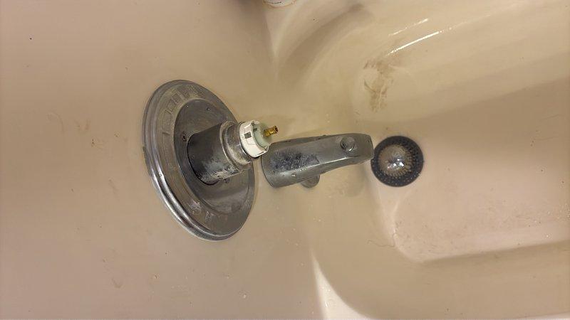 Responded to emergency call for continuous water flow from shower that would not shut off. Upon inspection, identified failed cartridge valve as the source of the problem. Removed deteriorated cartridge showing significant mineral buildup and corrosion on brass stems and O-ring failure. Installed replacement cartridge valve and tested operation to confirm proper shut-off function restored.