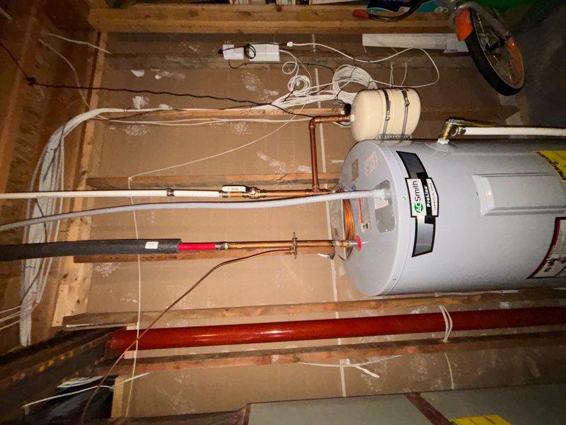 Responded to reported cold water faucet leak in common bathroom. Upon inspection, assessed plumbing fixtures and water supply connections. Examined water heater installation in attic space, including copper supply lines and drainage components. Replaced faulty valve component to resolve leak issue and ensure proper water flow control.